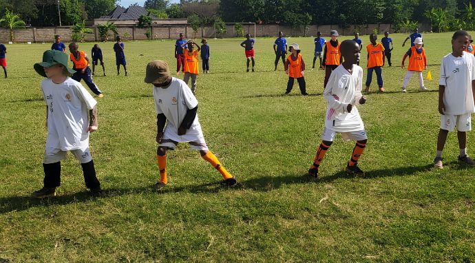 Niños con ropa y gorra durante una actividad deportiva segura al aire libre